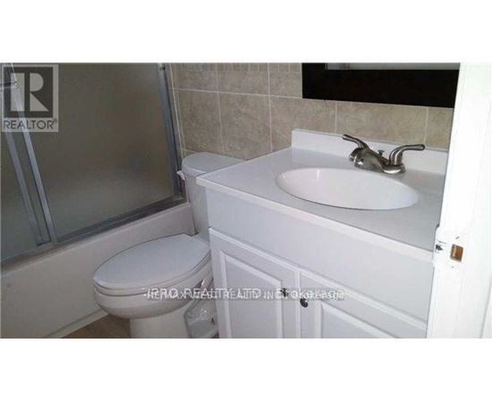 A white toilet sits next to a white sink in a bathroom.
