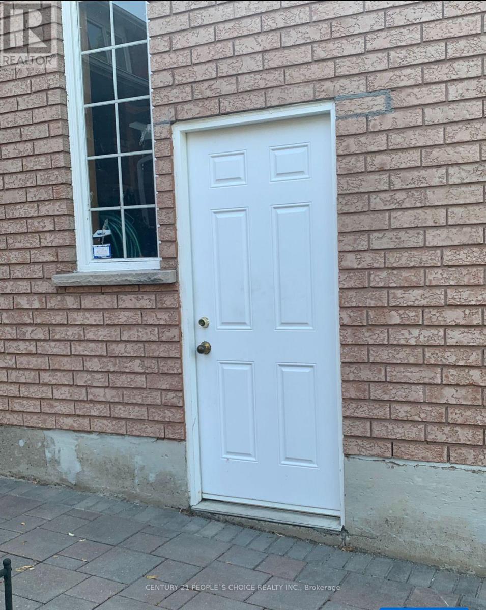 A white door is on the side of a brick building.