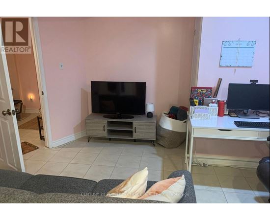 A living room with a television and a laptop on a desk.