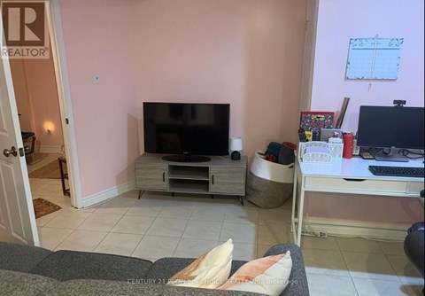 A living room with a television and a laptop on a desk.