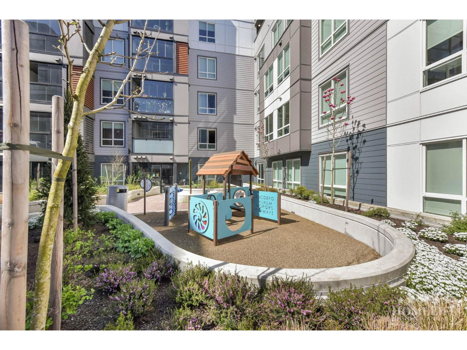A playground area with a slide and a sign that says "Playground" is surrounded by buildings.