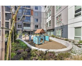 A playground area with a slide and a sign that says "Playground" is surrounded by buildings.
