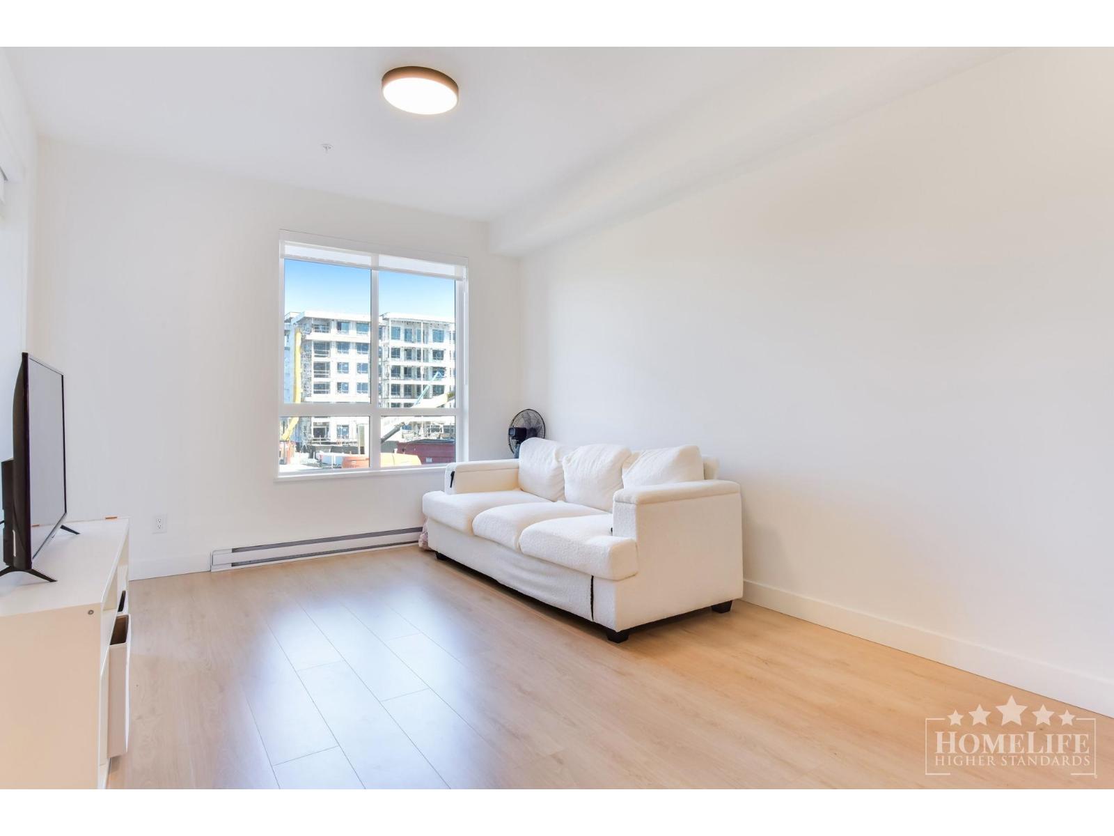 A living room with a white couch and a television.
