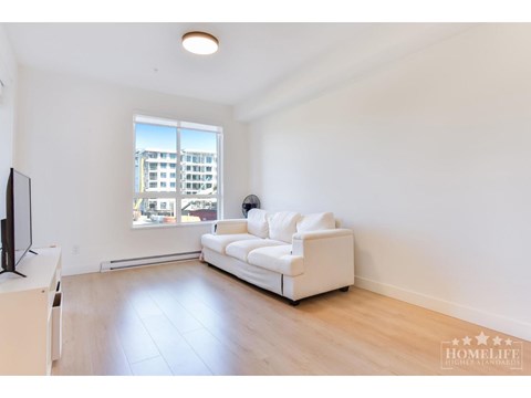 A living room with a white couch and a television.