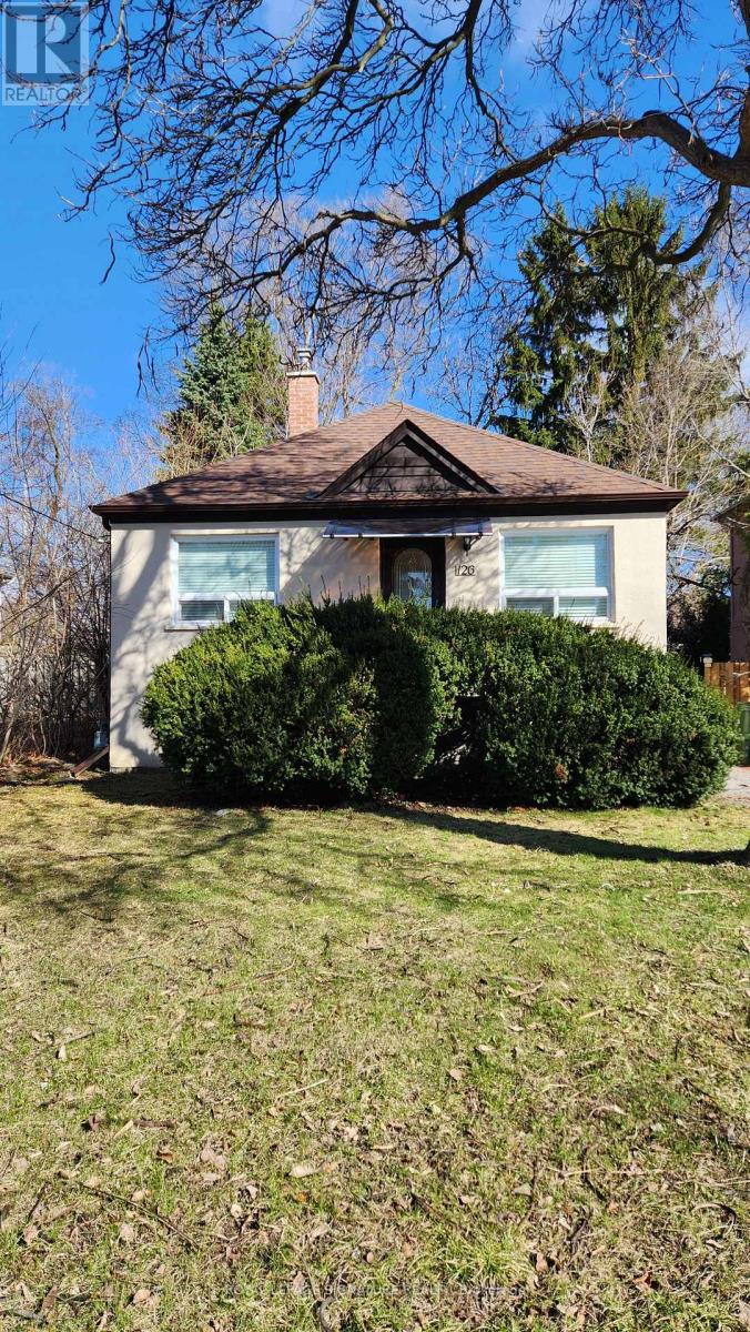 A house with a brown roof and a green lawn in front.