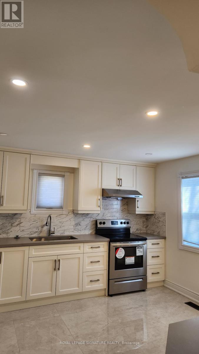 A kitchen with a stove top oven and a sink.