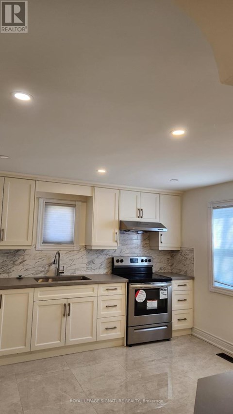 A kitchen with a stove top oven and a sink.