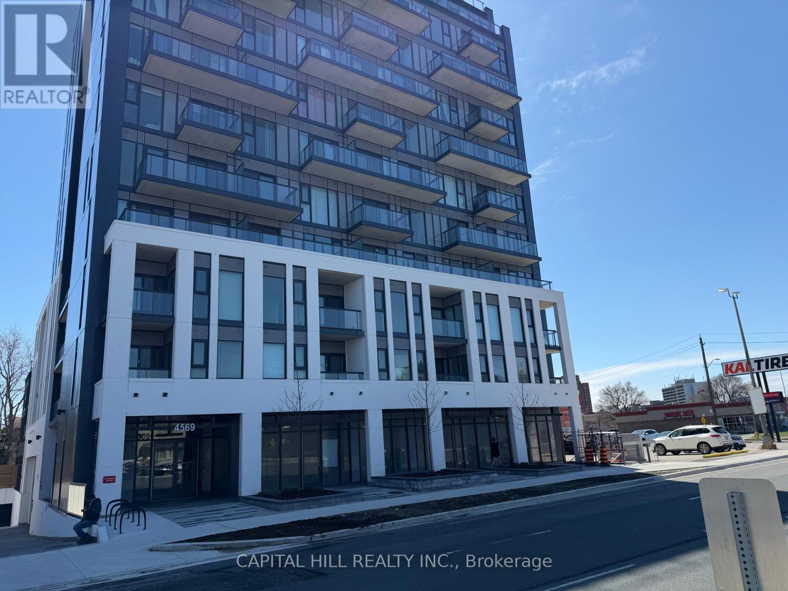 A tall white and blue building with the words "CAPITAL HILL REALTY INC., Brokerage" on the bottom.
