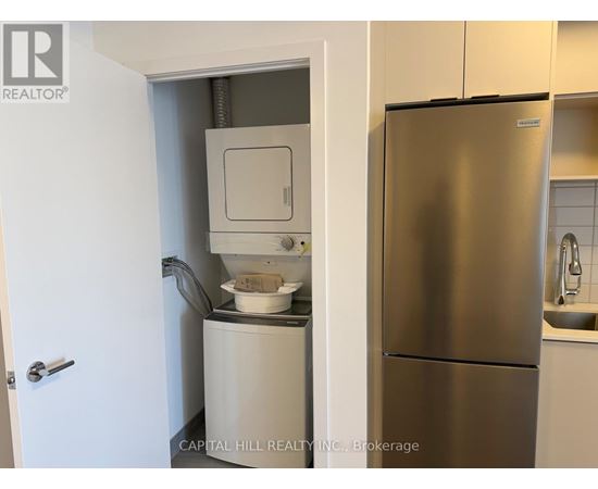A stainless steel refrigerator in a kitchen with a white door.