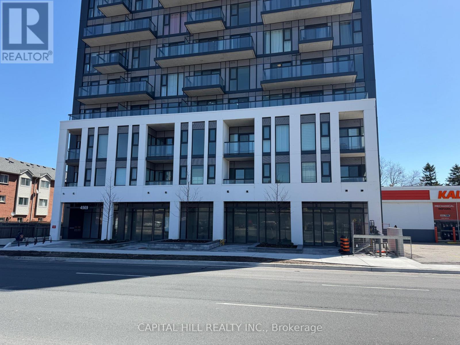 A tall white building with a glass facade is the main focus of the image.