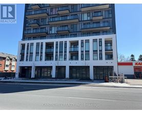 A tall white building with a glass facade is the main focus of the image.