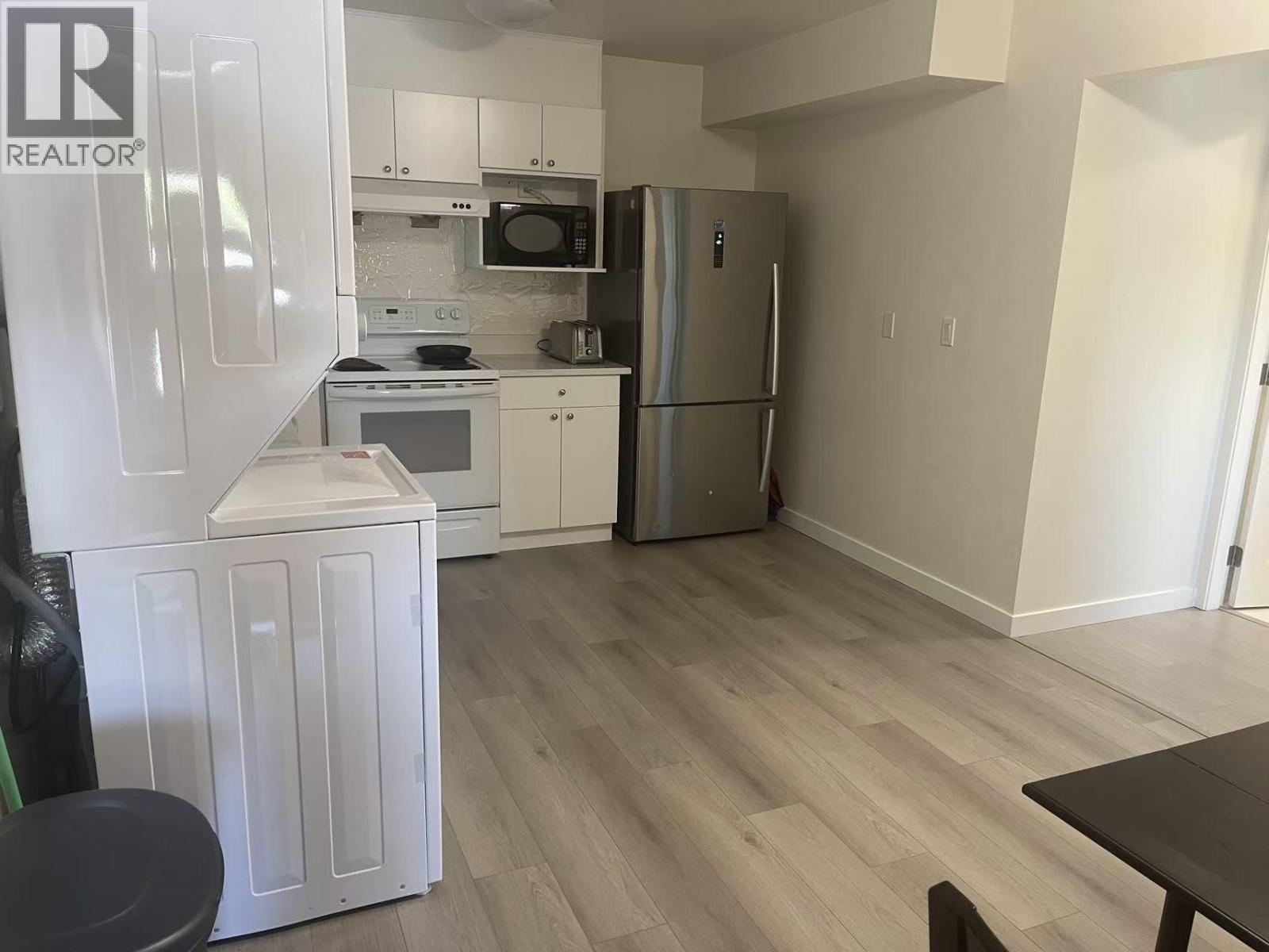 A kitchen with a refrigerator, microwave, oven, and dishwasher.