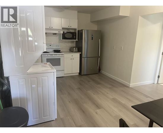 A kitchen with a refrigerator, microwave, oven, and dishwasher.