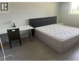 A bedroom with a bed, desk, and chair.