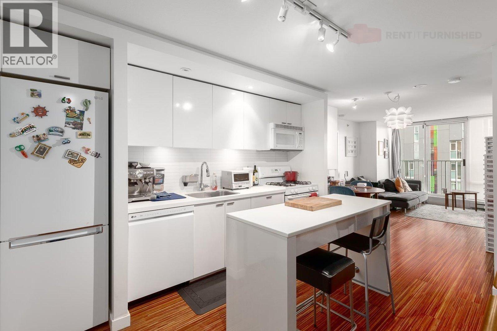 A kitchen with a white fridge and white cabinets.