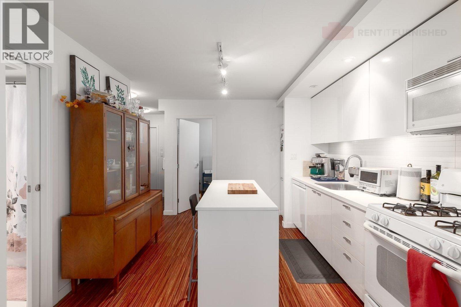 A kitchen with a white island in the middle of it.