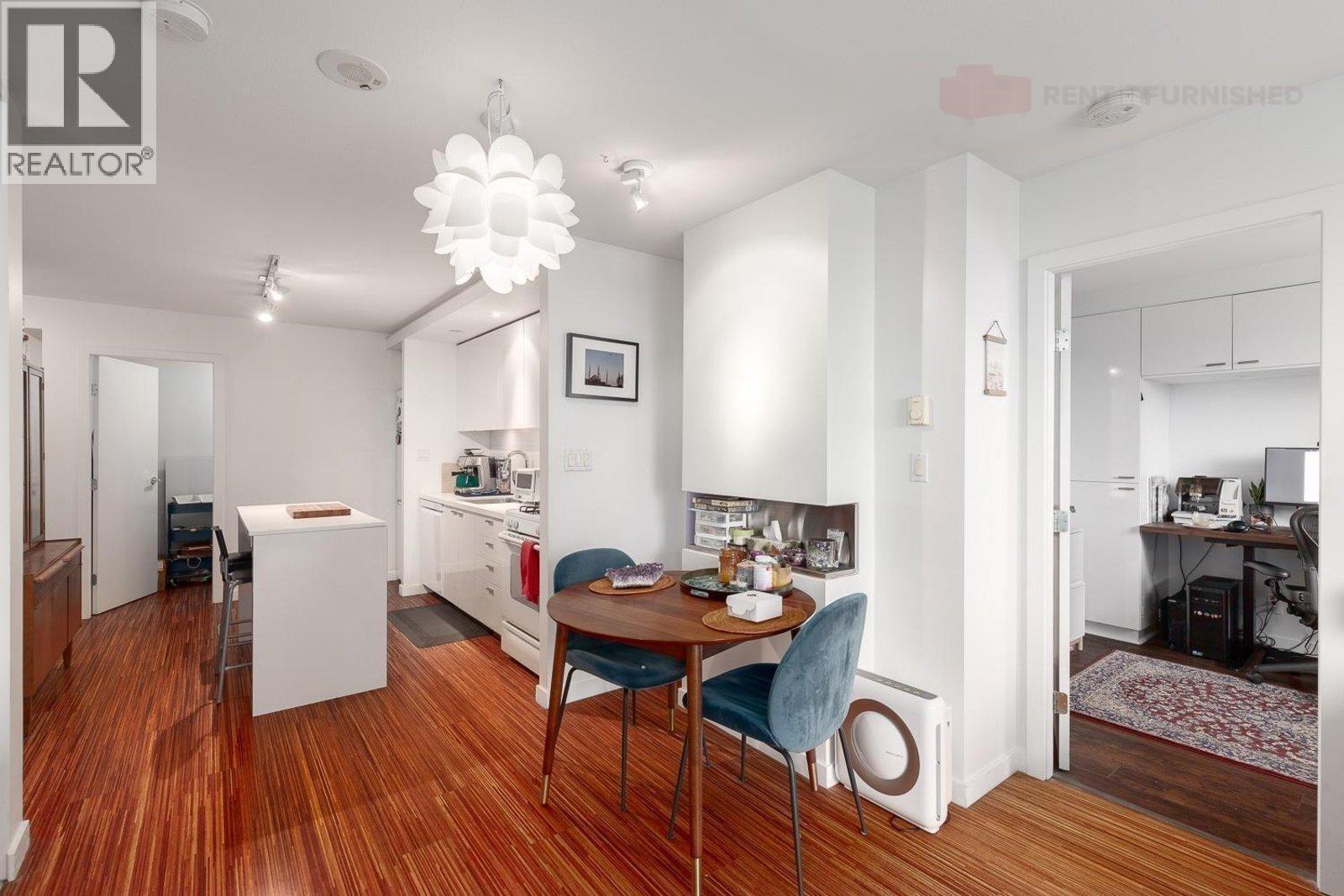 A dining room with a table and chairs.