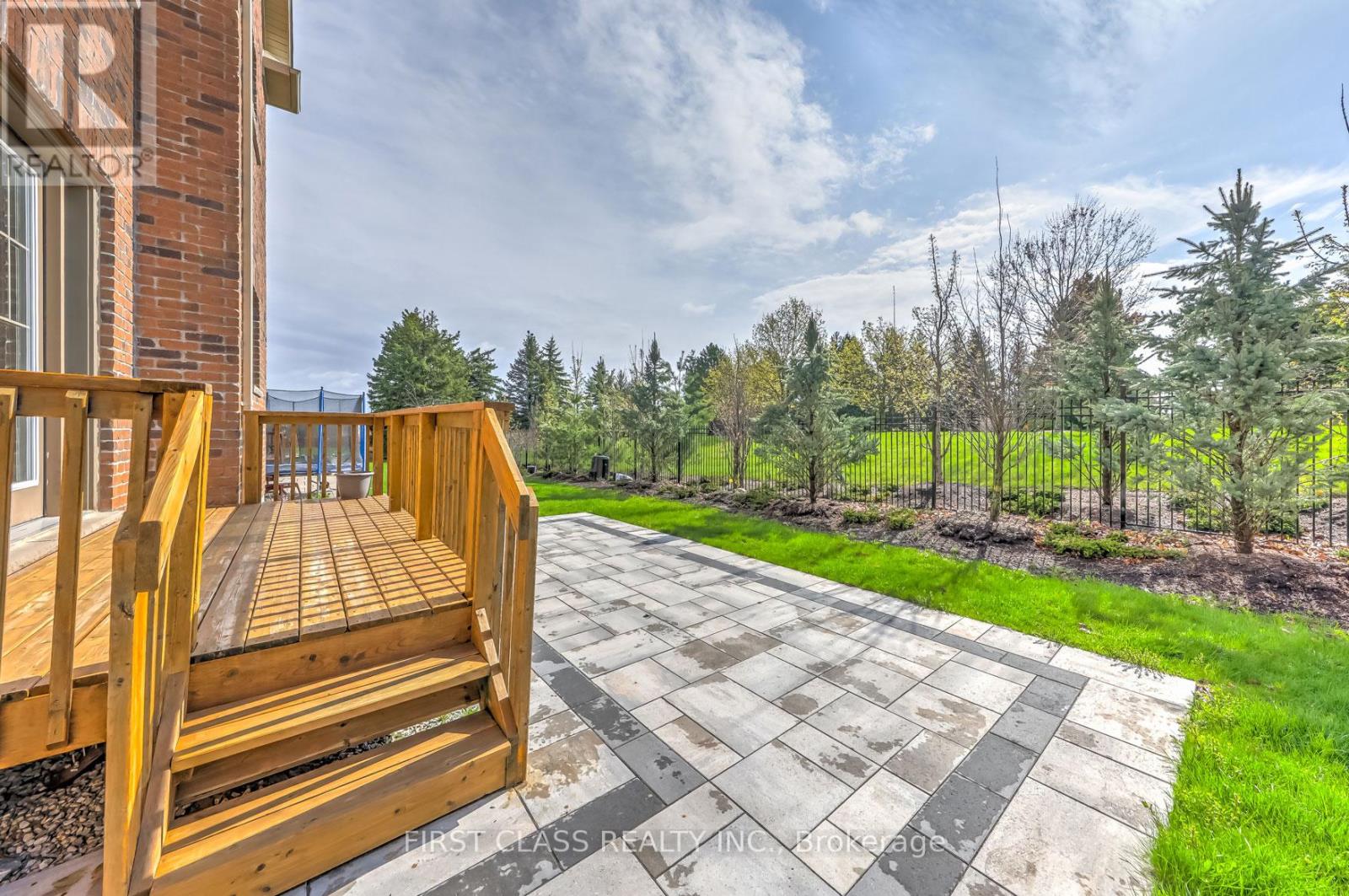 A wooden deck with a tiled floor leads to a grassy area.