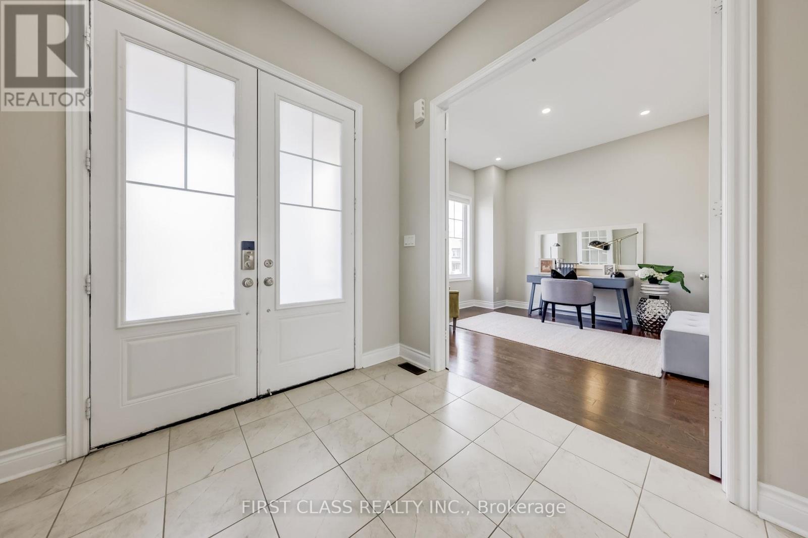 A spacious room with a dining area in the background.