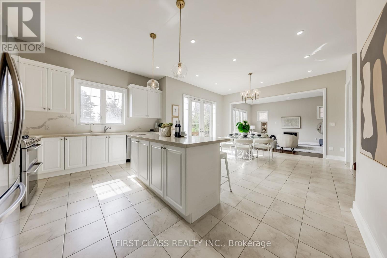 A spacious kitchen with white cabinets and a large island.