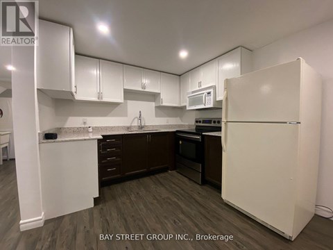 A kitchen with white cabinets and a white refrigerator.