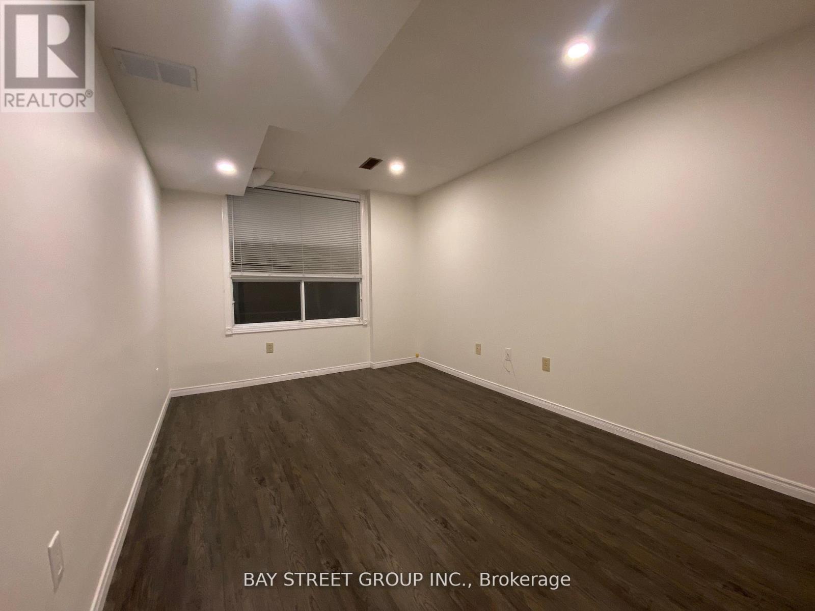 A room with a window and a wooden floor.