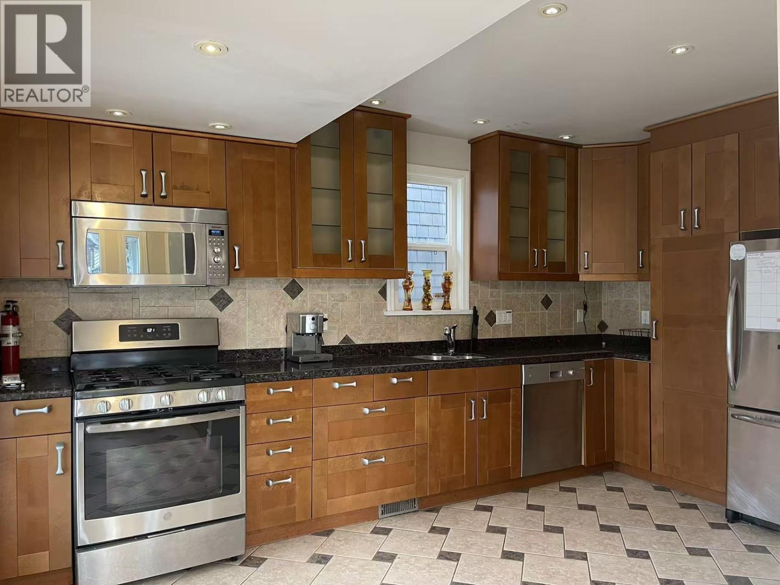 A kitchen with wooden cabinets and a black countertop.