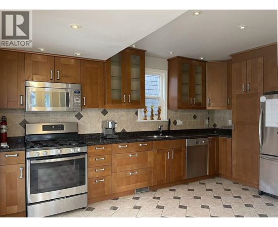 A kitchen with wooden cabinets and a black countertop.