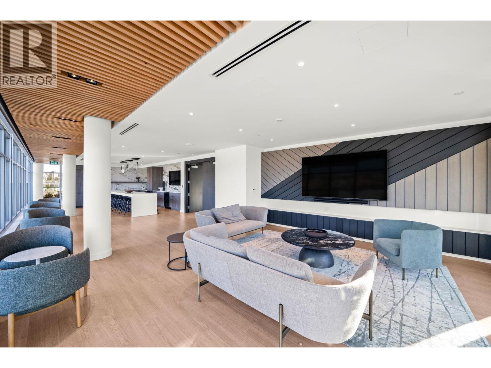 A living room with a grey couch and a wooden ceiling.