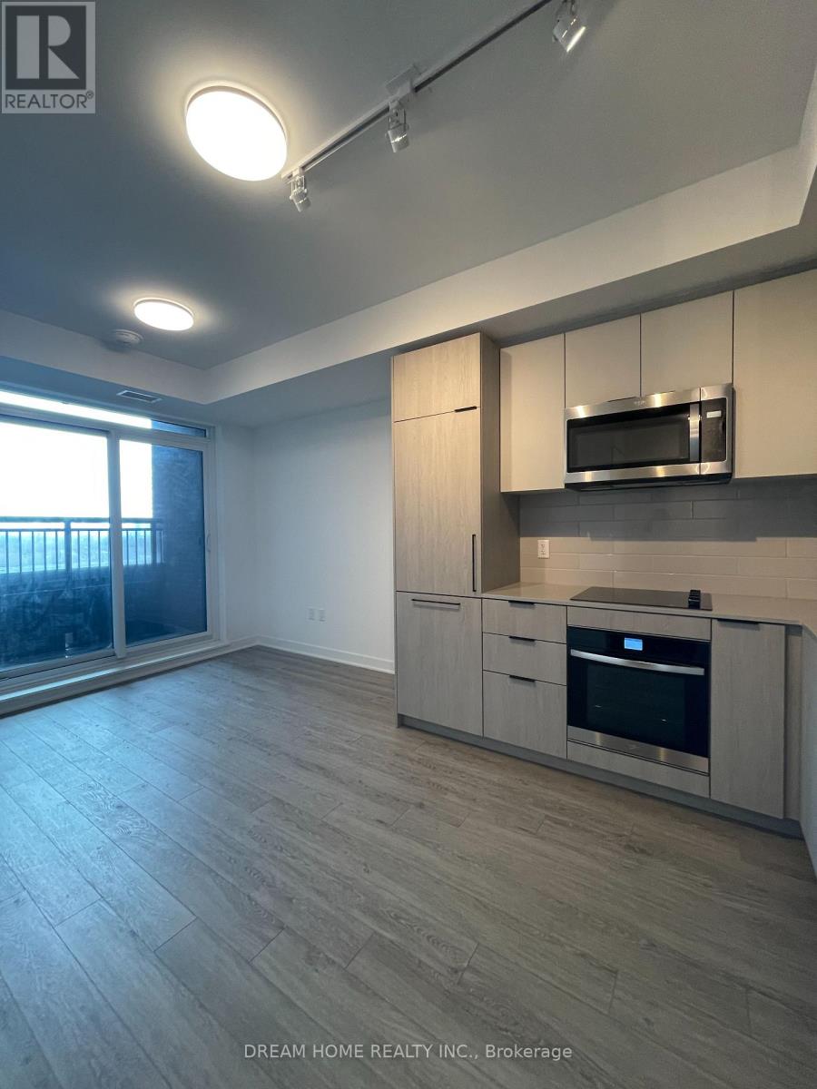 A modern kitchen with wooden cabinets and a stainless steel microwave.