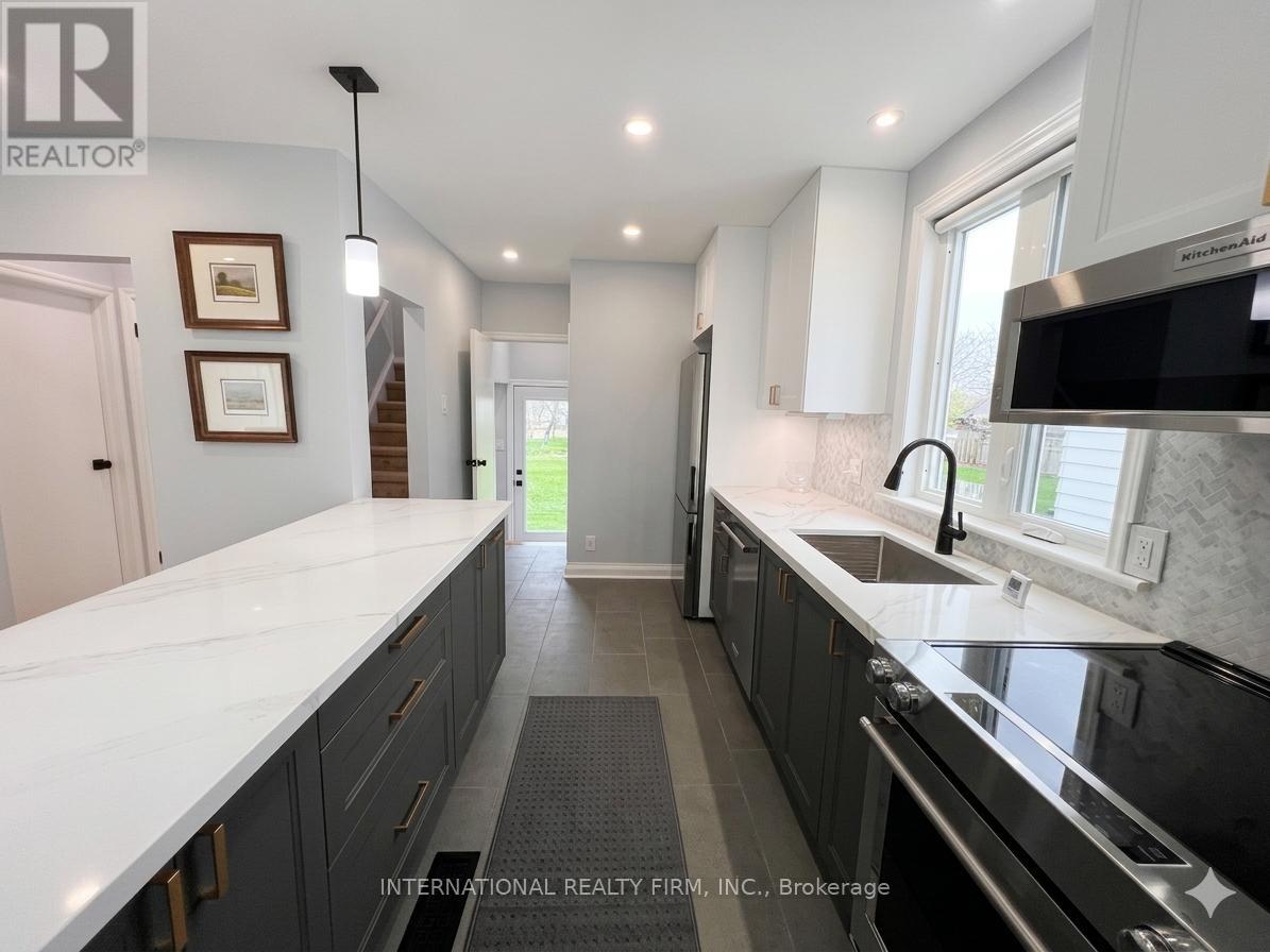 A modern kitchen with dark cabinets and a white countertop.