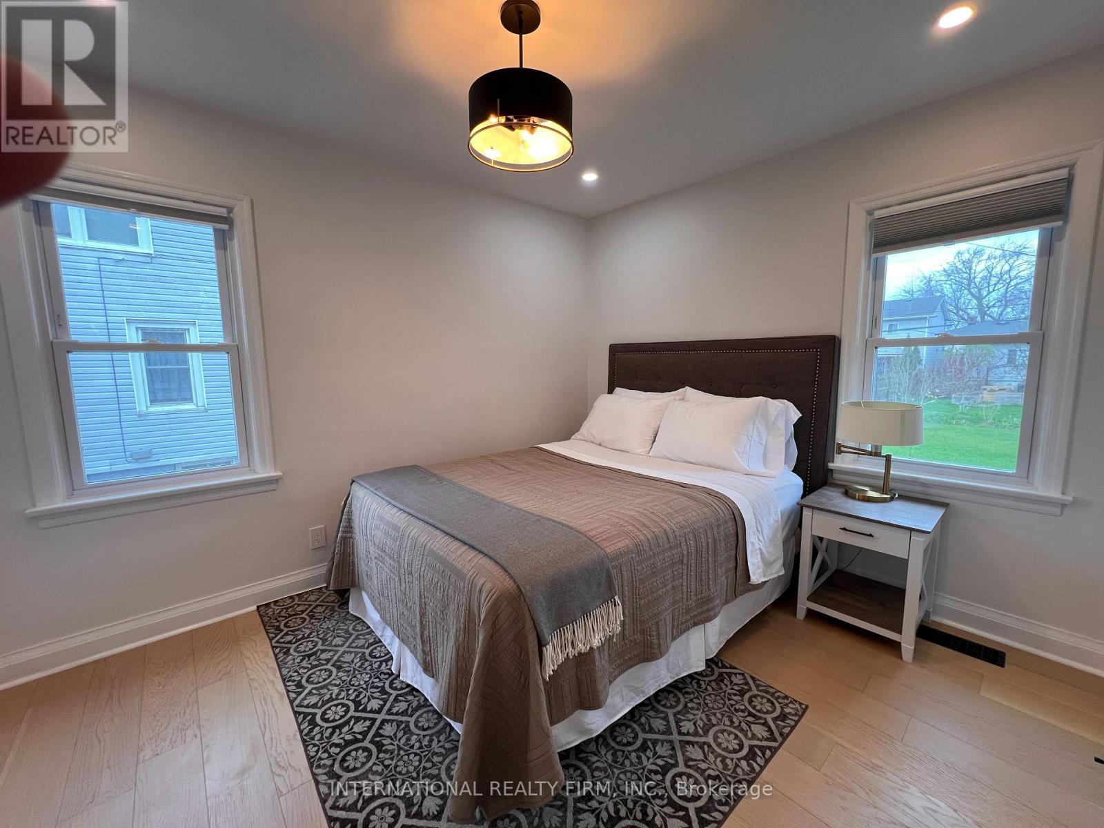 A bedroom with a bed, nightstand, and window.