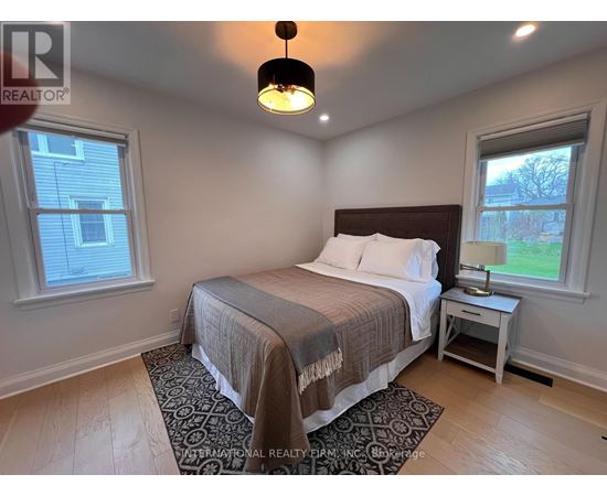 A bedroom with a bed, nightstand, and window.