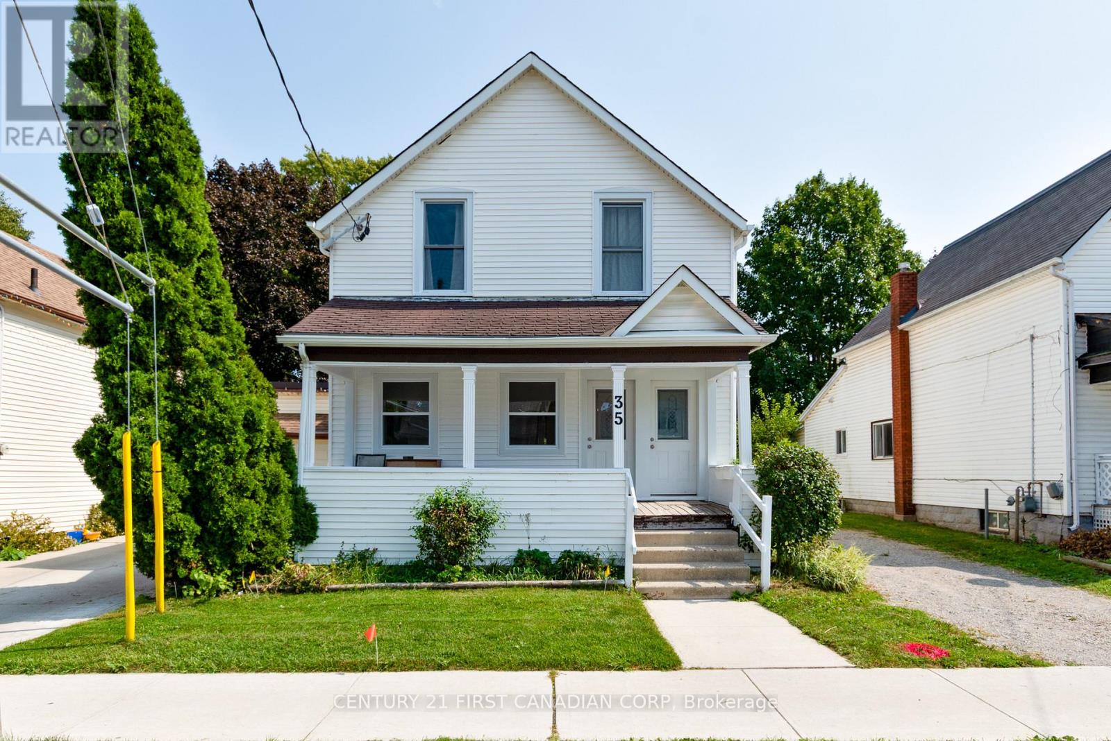 A white house with a brown roof and a small front porch.