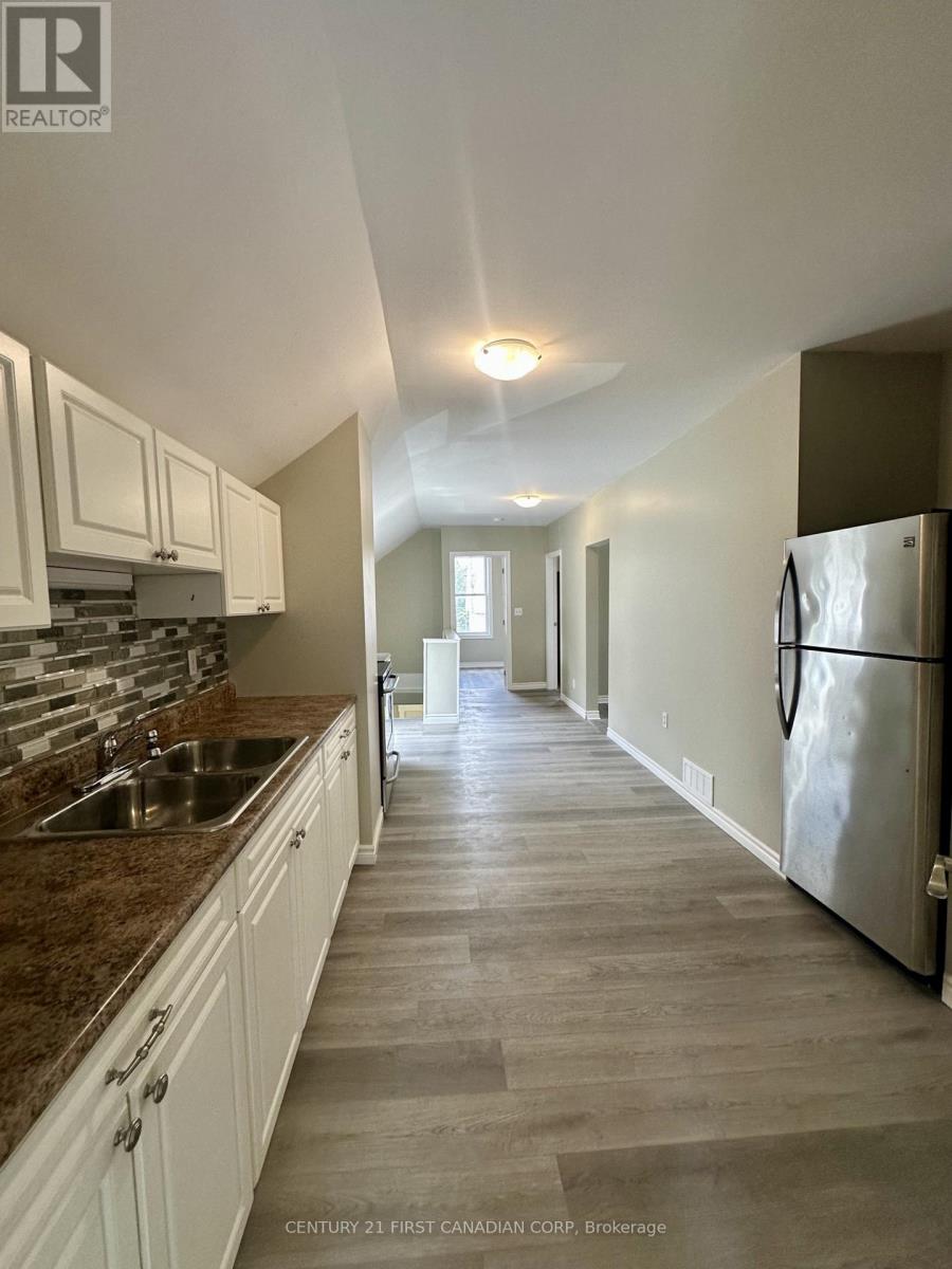 A kitchen with white cabinets and a marble countertop.