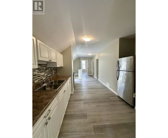 A kitchen with white cabinets and a marble countertop.