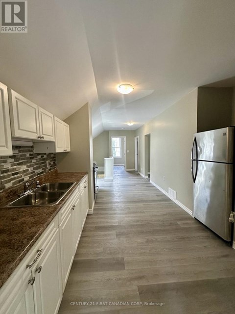 A kitchen with white cabinets and a marble countertop.