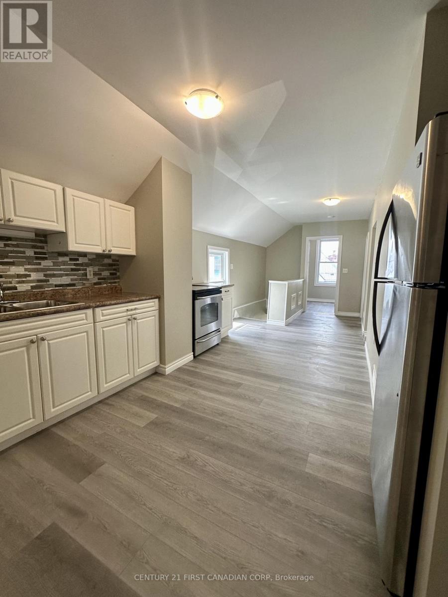 A kitchen with a refrigerator on the right side.