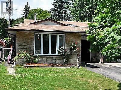 A small house with a grey roof and a white window.