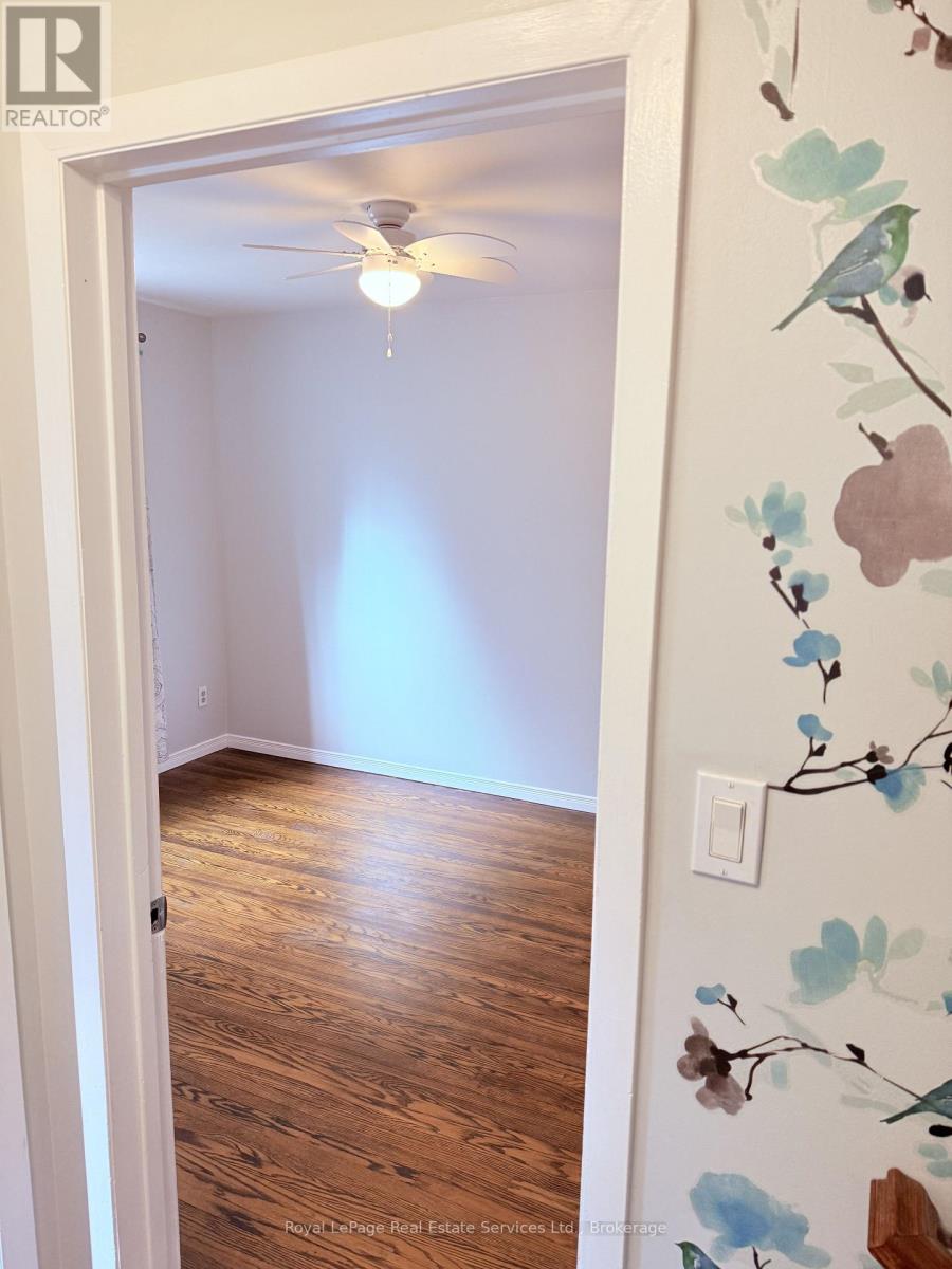 A room with a wooden floor and a ceiling fan.