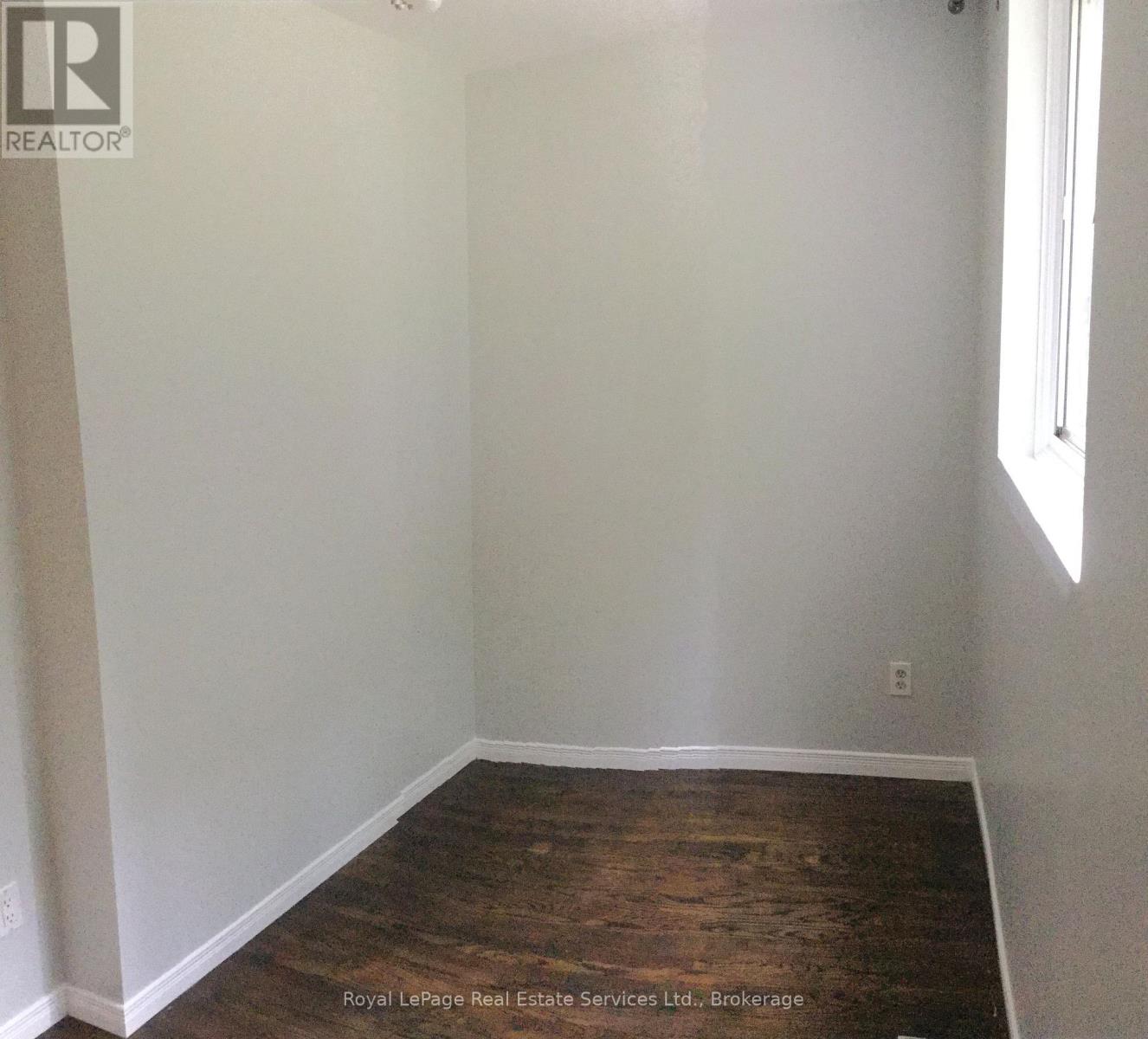 A room with white walls and wooden flooring.