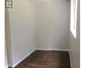 A room with white walls and wooden flooring.