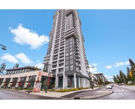 A tall building with a curved facade stands in front of a clear blue sky.