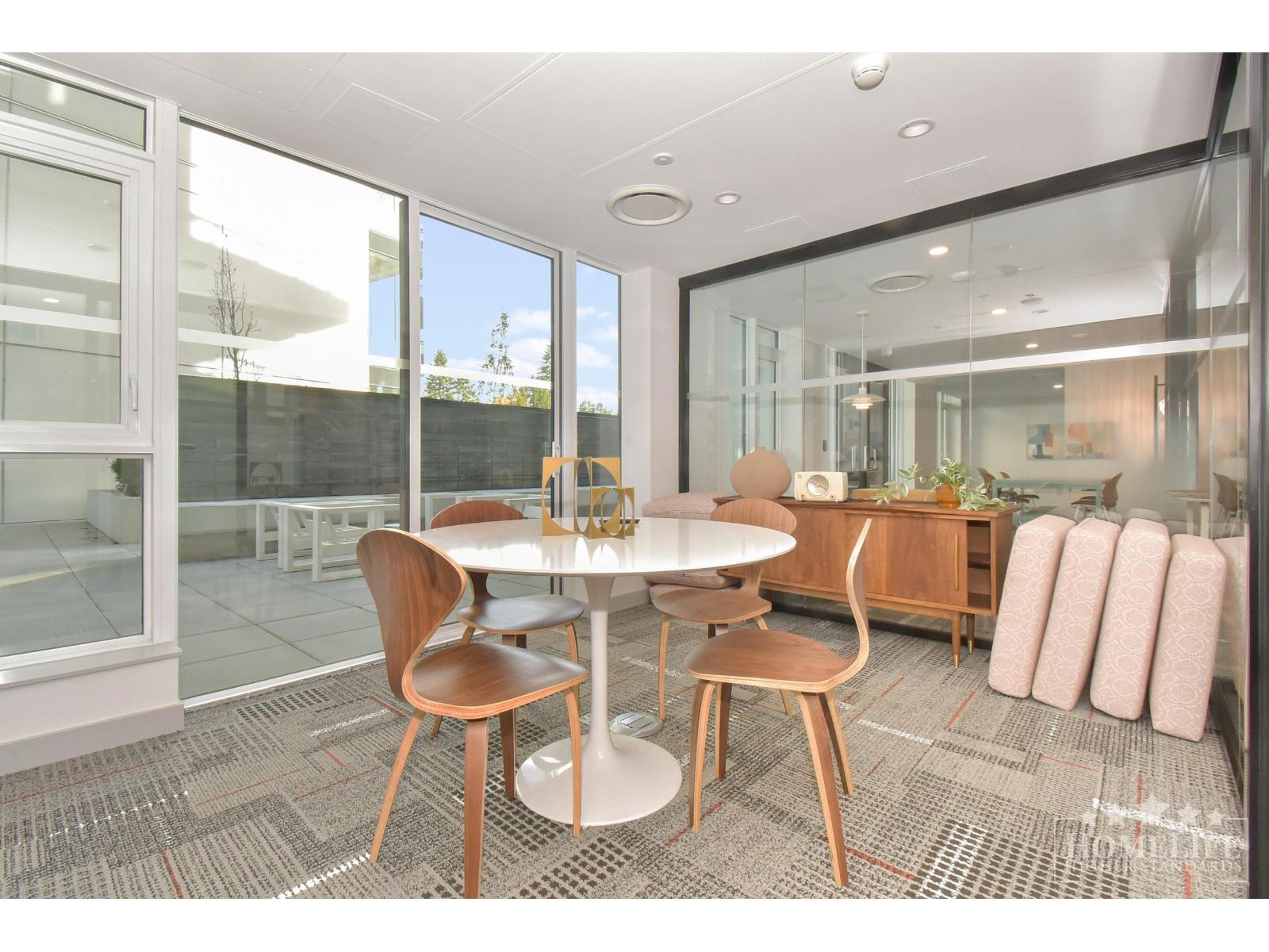 A modern dining room with a glass table and chairs.