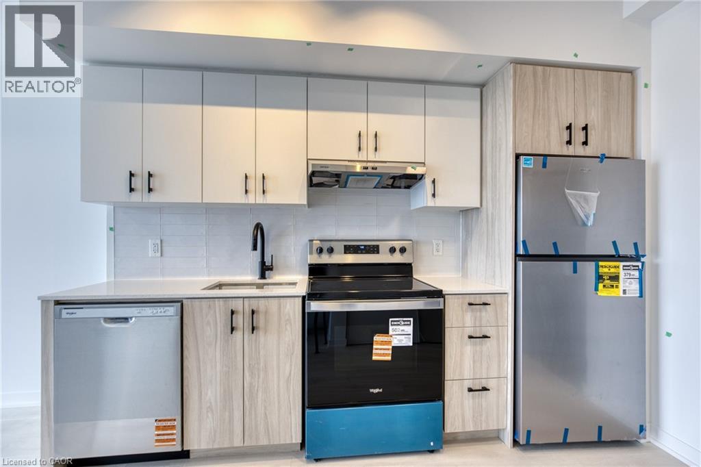 A kitchen with a blue dishwasher and a black oven.