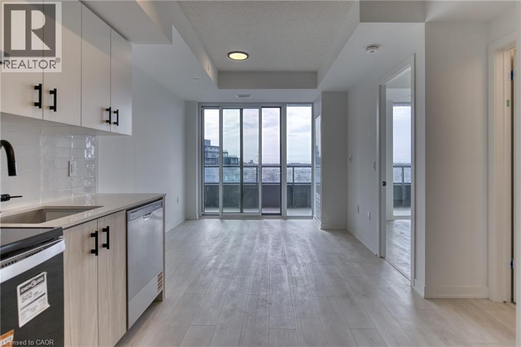 A modern kitchen with a stainless steel dishwasher and a refrigerator.