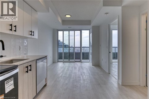 A modern kitchen with a stainless steel dishwasher and a refrigerator.