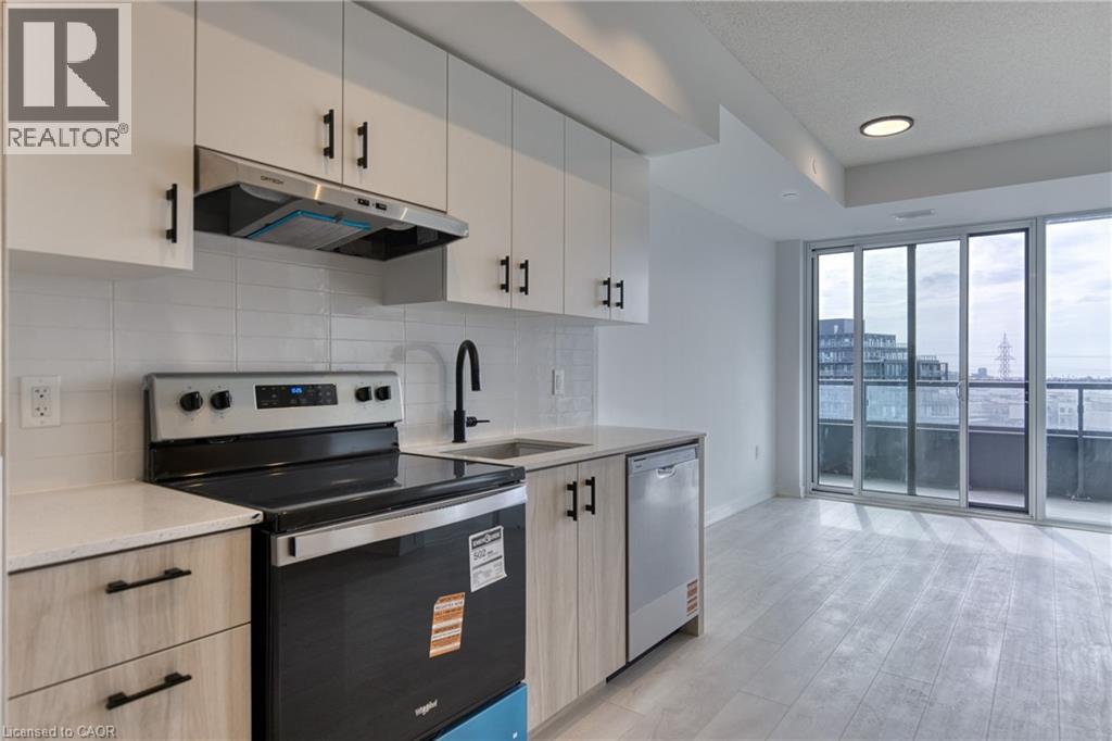 A modern kitchen with white cabinets and a black stove top oven.