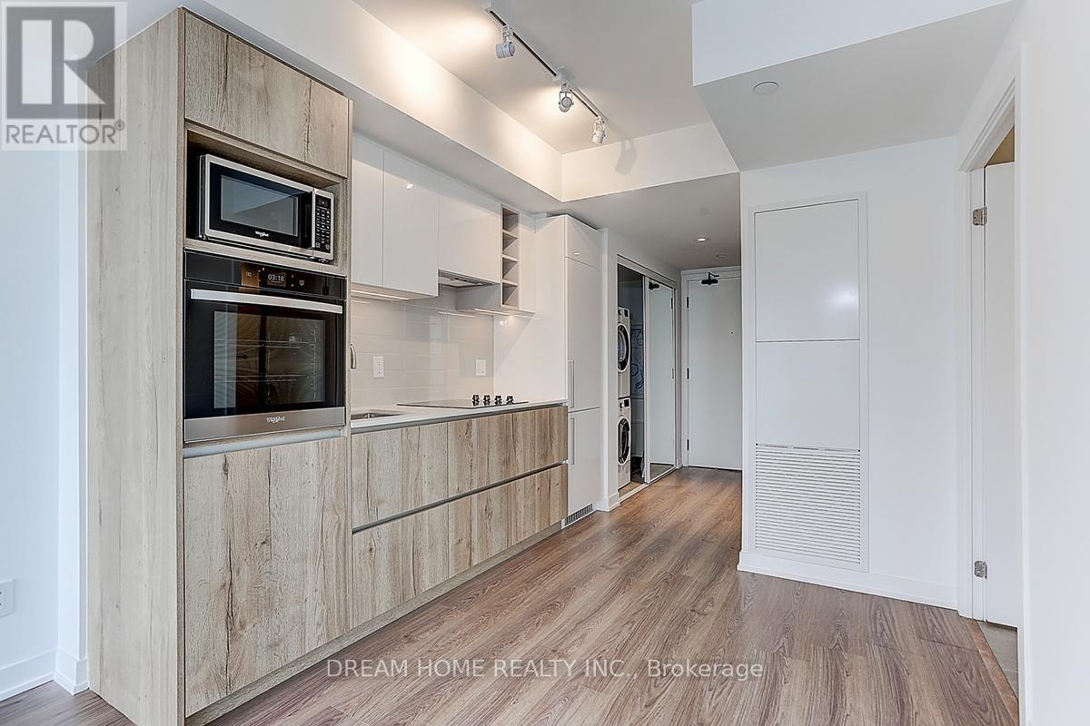 A modern kitchen with wooden cabinets and a microwave above the oven.