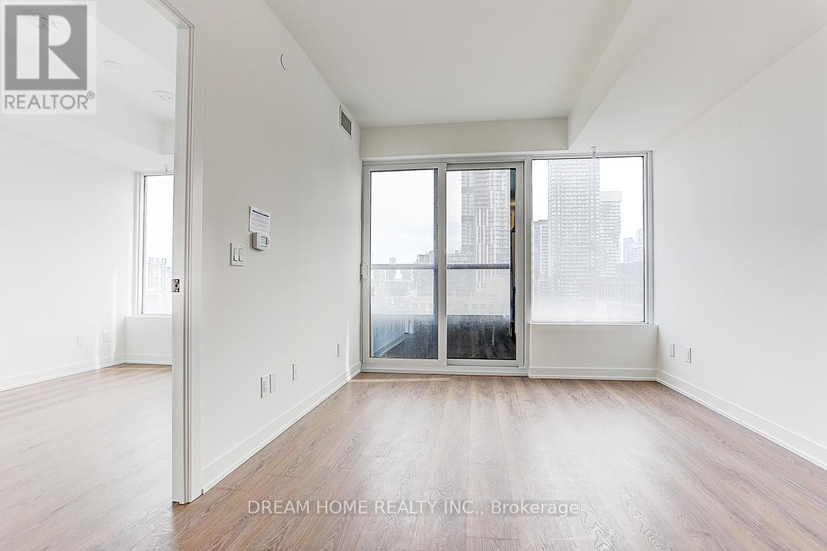 A spacious, empty room with a view of the city through a large window.